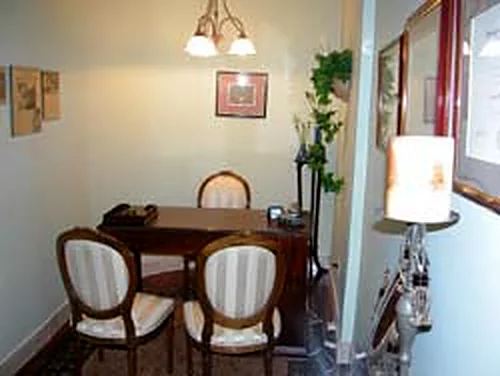 The private consultation room: a small table with two chairs, lamps and framed art