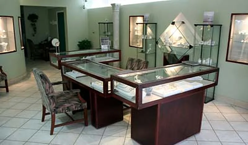 Inside the store: glass display cases, chairs for customers, and framed photographs